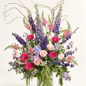Heirloom Meadow garden-style arrangement with blush roses, pink and purple flowers, blue hydrangea, greenery, and sculptural branches by a Santa Monica florist