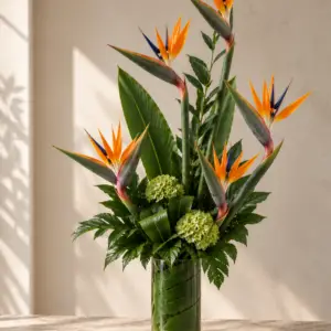 Tropical Daydream arrangement with Bird of Paradise flowers, green hydrangea, and tropical foliage in a leaf-lined glass vase by a Santa Monica florist