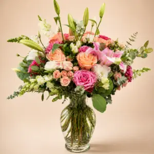 Garden Jubilee summer flower arrangement with pink roses, peach roses, pink lilies, white snapdragon, eucalyptus, and seasonal greenery in a clear glass vase by a Santa Monica flower studio.
